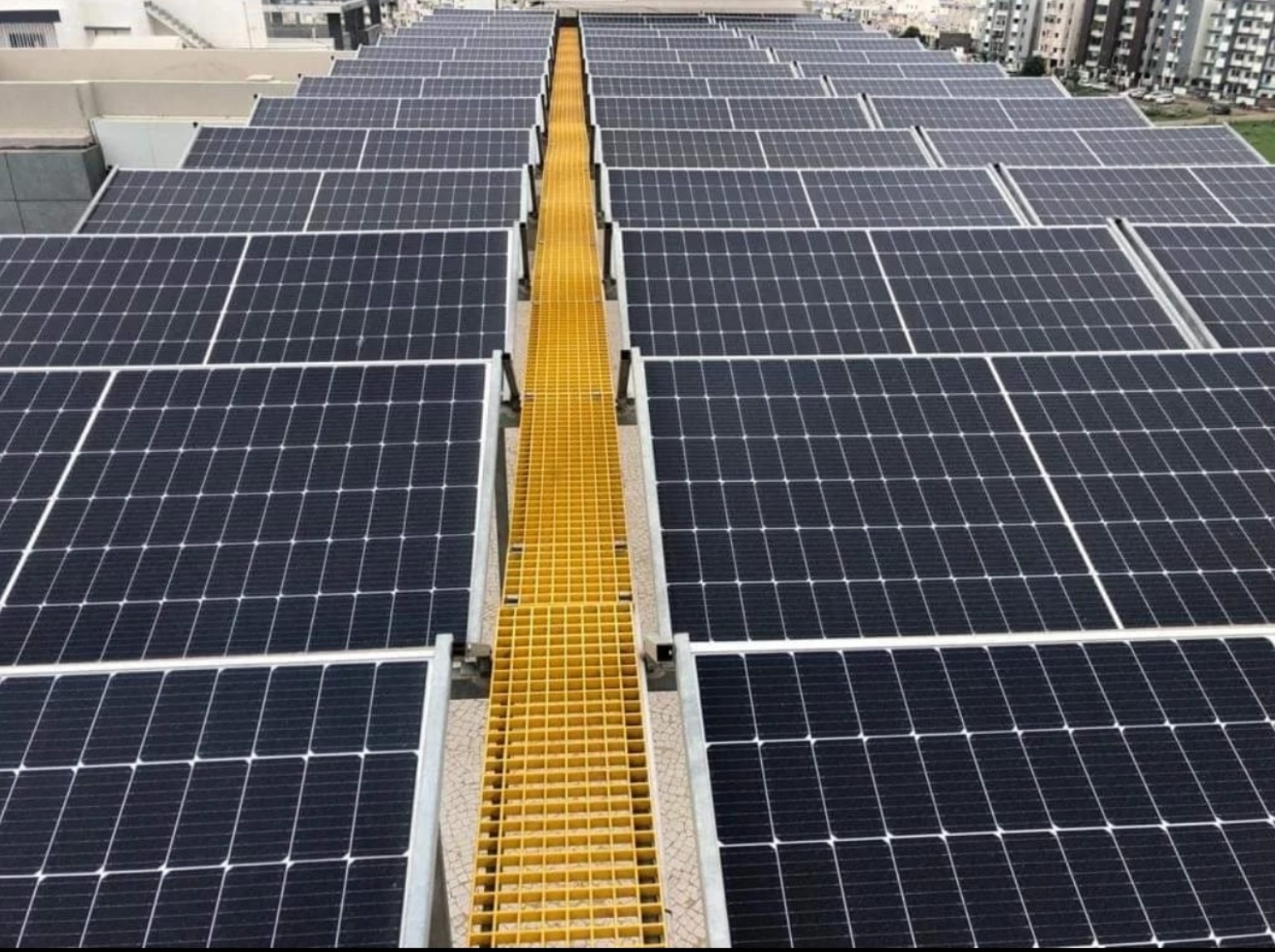 Rows of photovoltaic solar panels with a maintenance walkway
